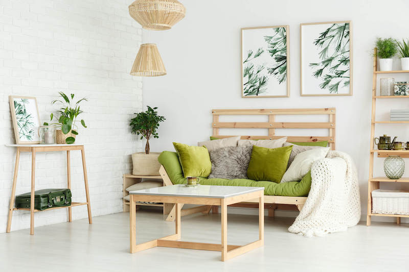 Modern living room interior with green sofa and botanical art